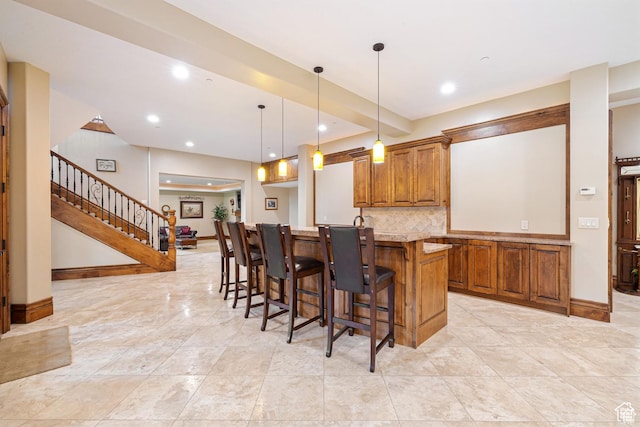 2499 River Meadows Ln, Midway, UT 84049 - kitchen with brown cabinets, a breakfast bar area, backsplash, hanging light fixtures, and recessed lighting