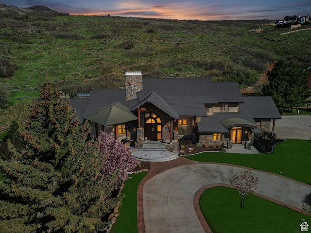 2499 River Meadows Ln, Midway, UT 84049 - view of front of property featuring stone siding, a chimney, curved driveway, and a yard