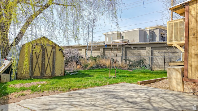 exterior space with a patio, an outdoor structure, central AC, fence, and a storage unit