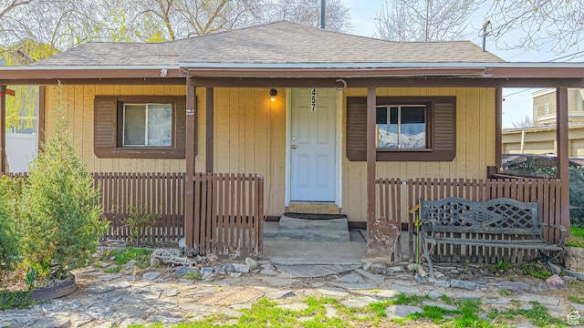 exterior space with entry steps and roof with shingles