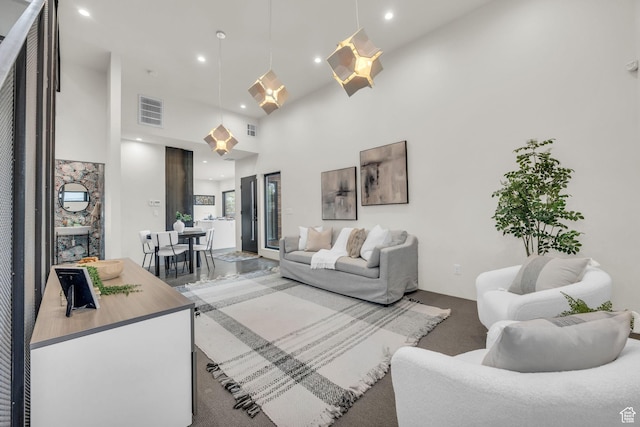 living room with visible vents, recessed lighting, carpet, and a towering ceiling