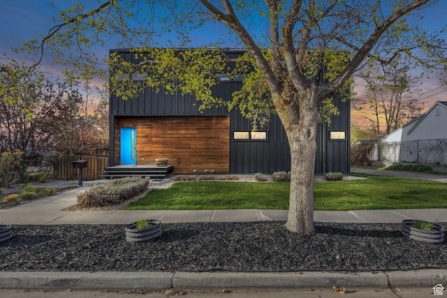 contemporary home featuring board and batten siding and a front lawn