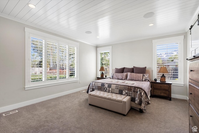 bedroom with a barn door, baseboards, and crown molding