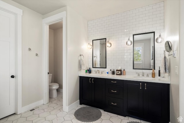 full bathroom with tile patterned floors, double vanity, a sink, and toilet