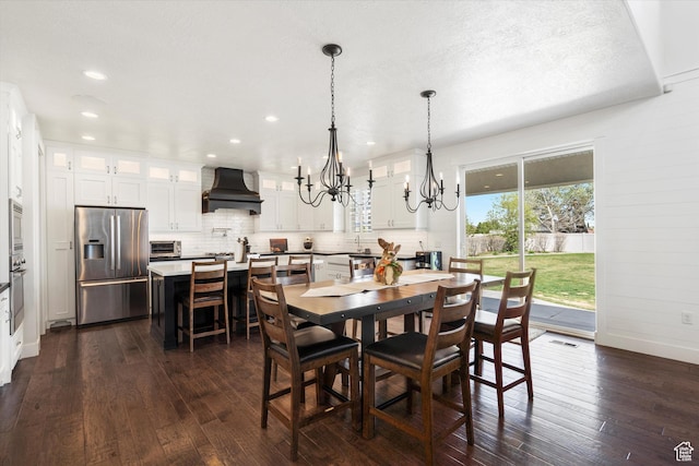 dining room with dark wood-style flooring, baseboards, recessed lighting, and a chandelier