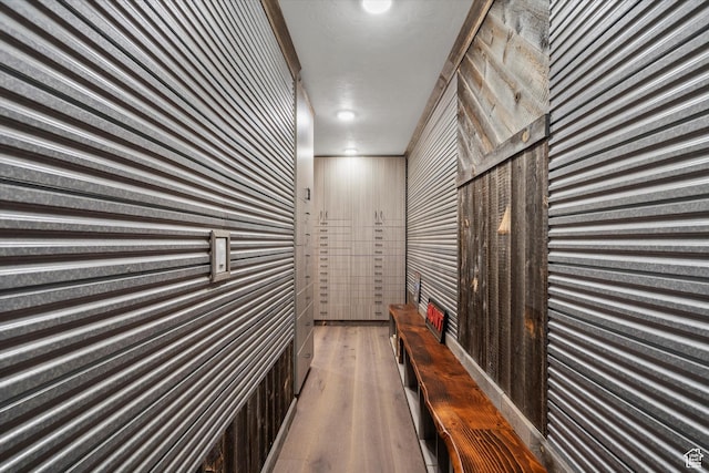 hallway featuring wooden walls and wood finished floors