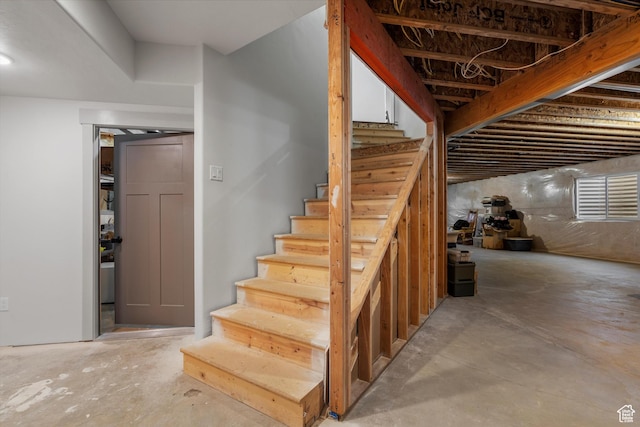 staircase with unfinished concrete floors