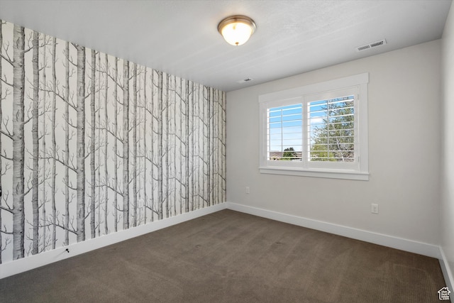 carpeted empty room featuring visible vents and baseboards