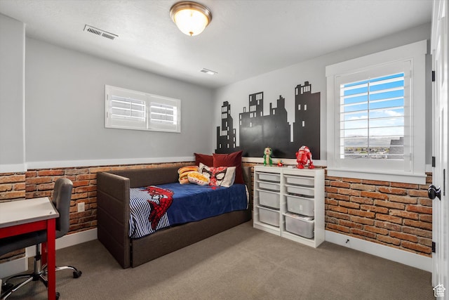 bedroom with visible vents, multiple windows, carpet flooring, and brick wall