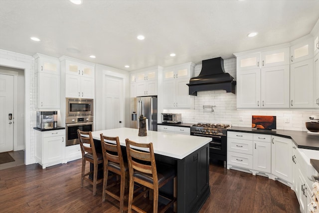 kitchen with stainless steel appliances, custom exhaust hood, dark wood-type flooring, and white cabinets