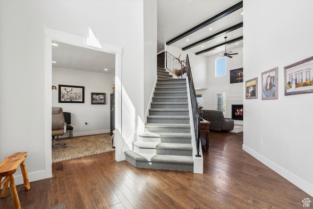 staircase with a lit fireplace, recessed lighting, a ceiling fan, and hardwood / wood-style flooring