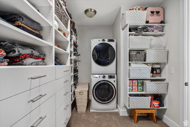 clothes washing area featuring carpet floors, baseboards, stacked washing maching and dryer, and laundry area