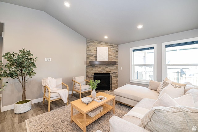 living area featuring baseboards, wood finished floors, a fireplace, and lofted ceiling
