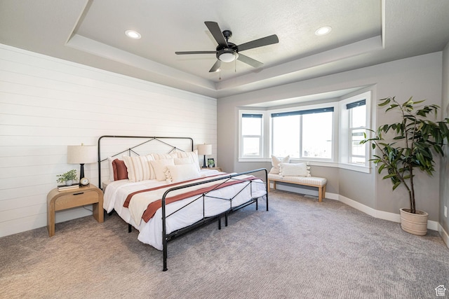 bedroom featuring a tray ceiling, recessed lighting, and light carpet