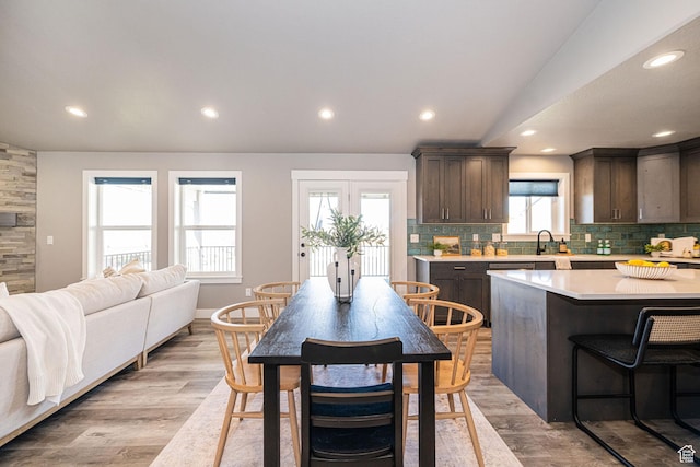 kitchen with backsplash, light countertops, recessed lighting, and dark brown cabinetry