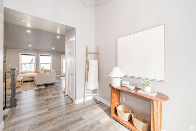 corridor with wood finished floors, baseboards, and recessed lighting