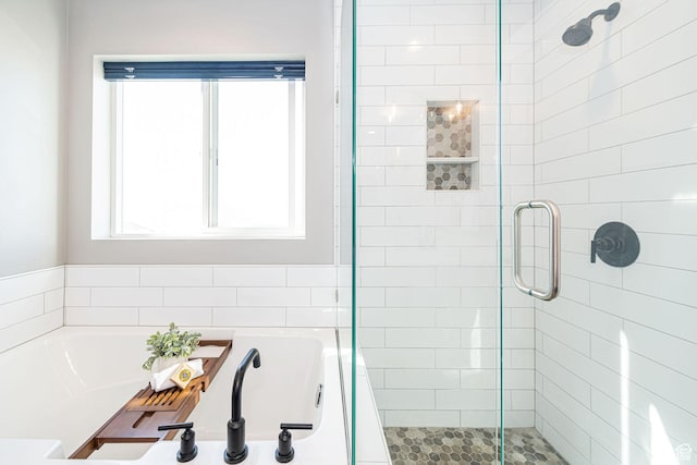 bathroom with a shower stall and a bath