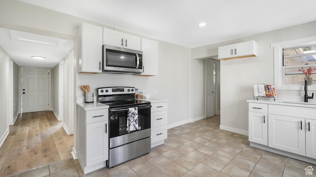55 S Cooley St, Grantsville, UT 84029 - kitchen featuring stainless steel appliances, white cabinets, light countertops, and a sink