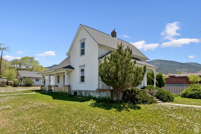 205 S Main St, Manti, UT 84642 - view of side of home with a lawn, a chimney, a mountain view, stucco siding, and a shingled roof