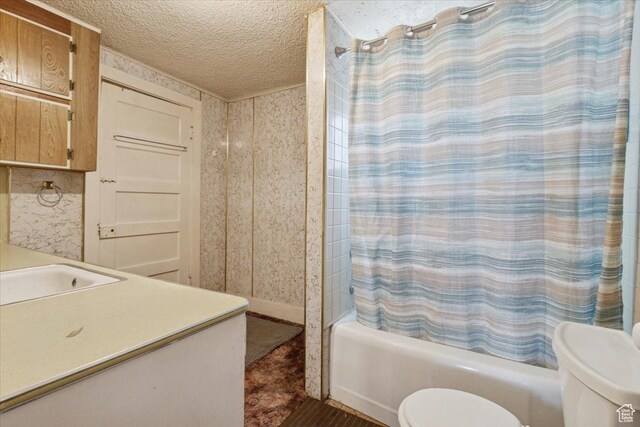 205 S Main St, Manti, UT 84642 - bathroom with toilet, a textured ceiling, shower / bath combo with shower curtain, wallpapered walls, and a sink