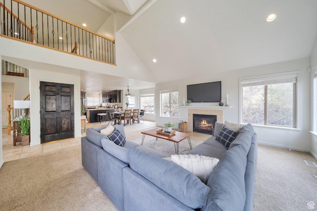 tiled living room featuring carpet flooring, baseboards, recessed lighting, a tile fireplace, and high vaulted ceiling