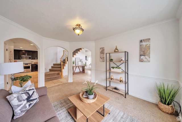 living area with light colored carpet, arched walkways, ornamental molding, and stairs