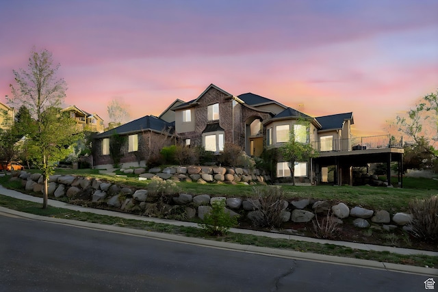 french country style house featuring stone siding and a wooden deck