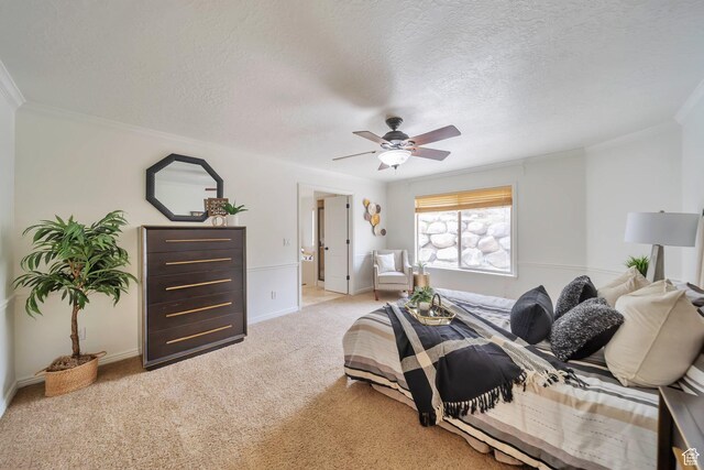 bedroom with crown molding, a textured ceiling, ceiling fan, light colored carpet, and baseboards