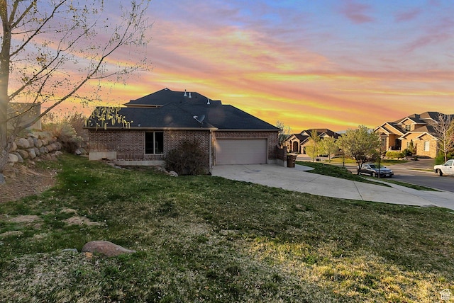 view of front of house with a residential view, a front lawn, driveway, brick siding, and a garage
