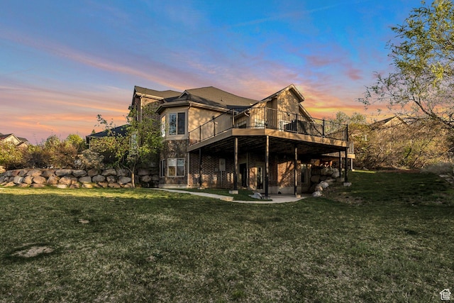 back of house with a lawn, a wooden deck, and a patio