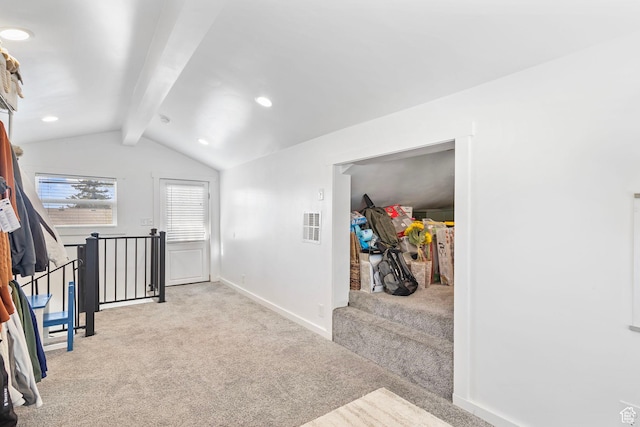 hallway with carpet flooring, visible vents, baseboards, and vaulted ceiling with beams