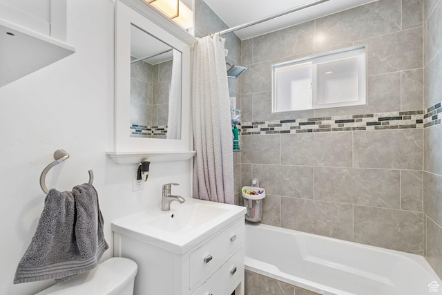 full bathroom with tiled shower / bath combo, toilet, and vanity