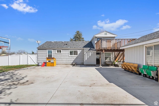 rear view of property with a patio, roof with shingles, stairway, a wooden deck, and fence