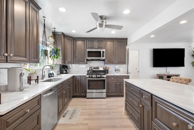 kitchen featuring recessed lighting, a sink, dark brown cabinets, and stainless steel appliances