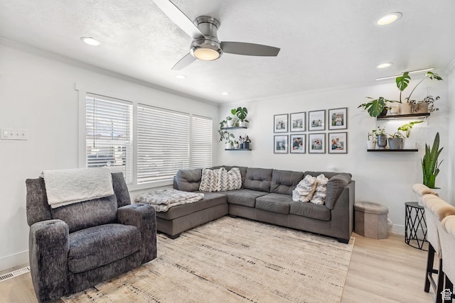 living area with visible vents, ceiling fan, crown molding, recessed lighting, and wood finished floors