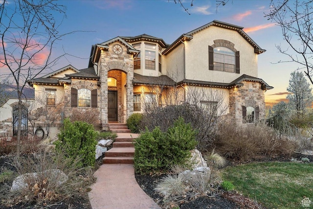 mediterranean / spanish-style home with stucco siding and stone siding