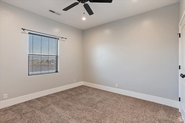 carpeted spare room featuring ceiling fan, baseboards, and visible vents