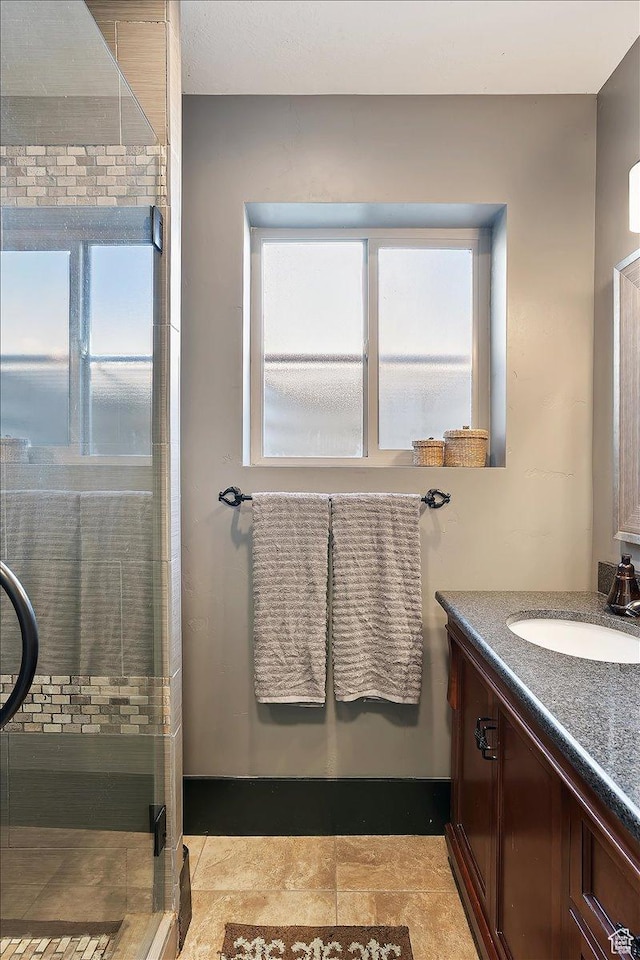 full bath with a stall shower, a healthy amount of sunlight, and vanity