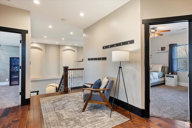 living area featuring baseboards, arched walkways, a ceiling fan, hardwood / wood-style flooring, and recessed lighting