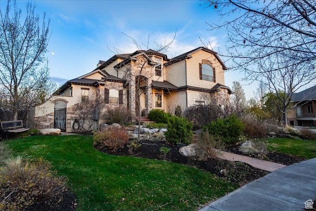 view of front of property featuring stucco siding, stone siding, and a front yard