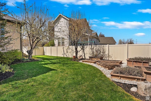 view of yard with fence and a vegetable garden