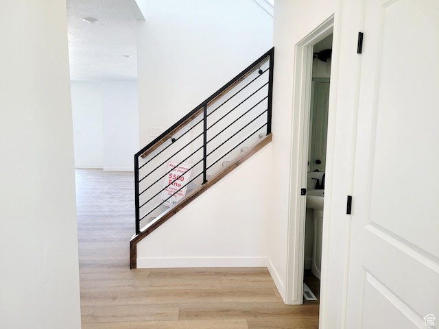 stairway with baseboards and wood finished floors