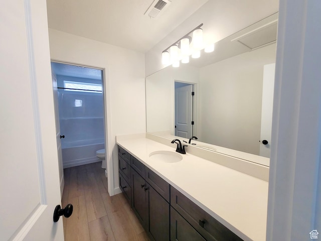 full bath featuring vanity, toilet, wood finished floors, and visible vents