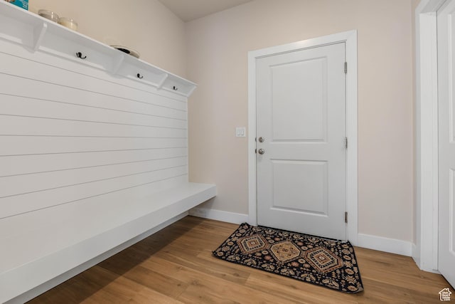 mudroom featuring light wood-style flooring and baseboards