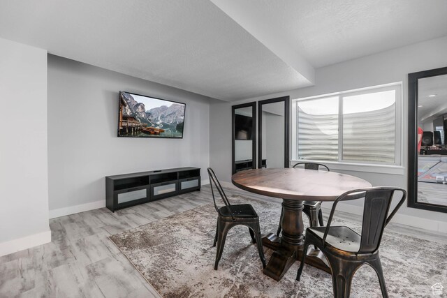 dining area with baseboards and a textured ceiling
