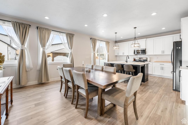 dining room featuring recessed lighting, light wood-style flooring, and baseboards