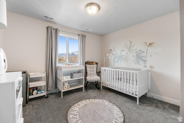 bedroom with a nursery area, visible vents, carpet floors, a mountain view, and baseboards