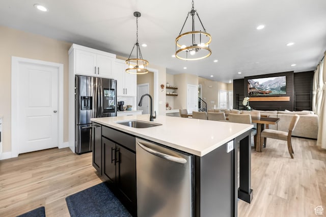 kitchen with white cabinets, an inviting chandelier, a sink, appliances with stainless steel finishes, and recessed lighting