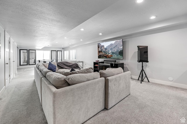 living area with a textured ceiling, light colored carpet, baseboards, and recessed lighting