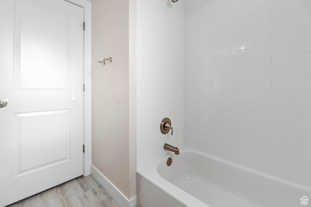full bathroom with baseboards, wood finished floors, and tub / shower combination